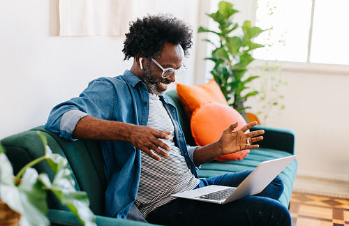 Remote worker engaging with his colleagues during a video call in his home office