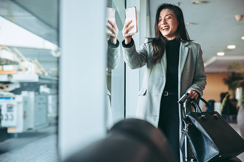 Female airline passenger taking selfie at waiting lounge