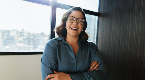 Professional woman in blue blouse smiling in office setting
