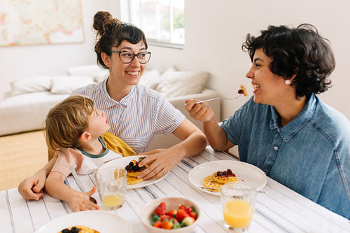 Female couple with son having breakfast