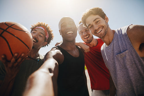 Men playing basketball posing for photo