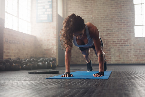 Young muscular woman doing core exercise