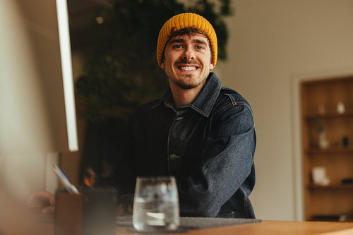 Man works in a casual office workspace at his computer desk