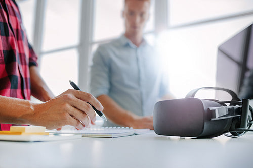 Virtual reality glasses on table with men working