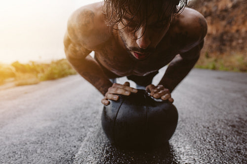 Man doing push up on medicine ball