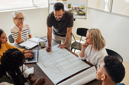 Architects discussing design plans in a collaborative meeting at an architecture firm