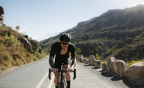 Professional cyclist riding on mountain road