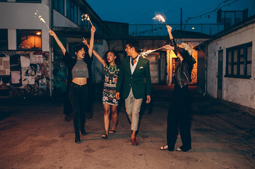 Group of friends enjoying with sparklers in evening
