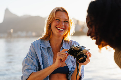 Young woman with camera enjoying travel in Brazil by the waterside