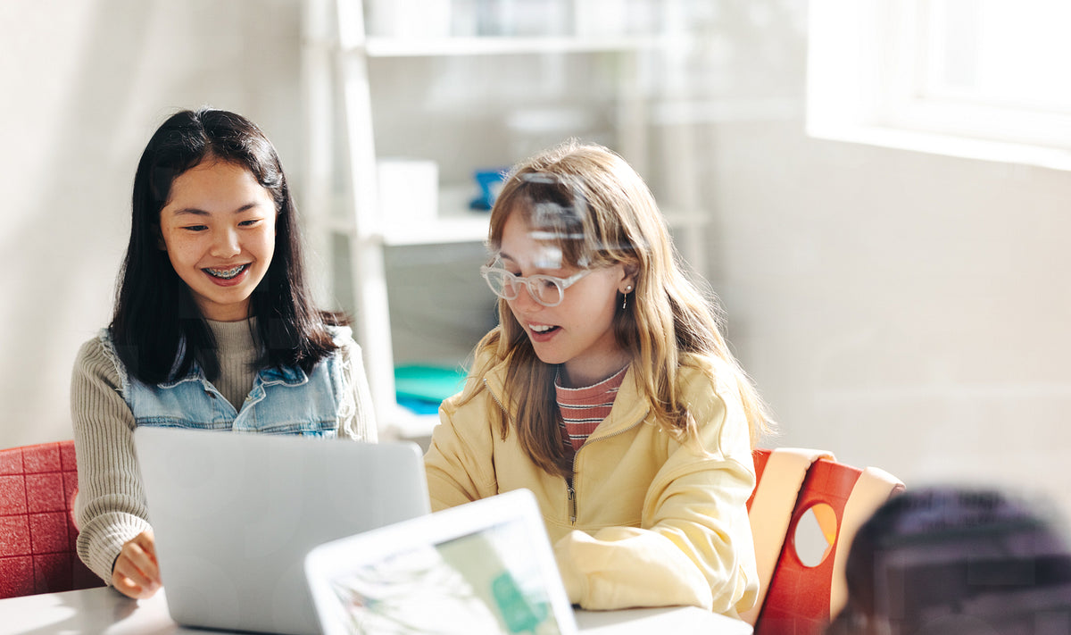 Girls enjoy participating in a computer science lesson as a pair ...