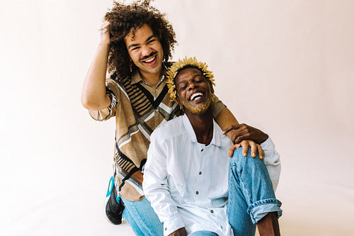Confident gay couple smiling cheerfully in a studio