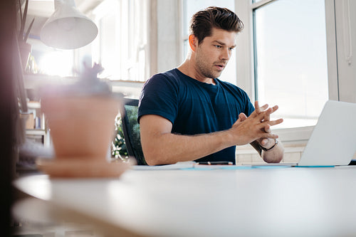 Young businessman looking at laptop in office