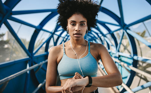 Sportswoman checking pulse on smart watch