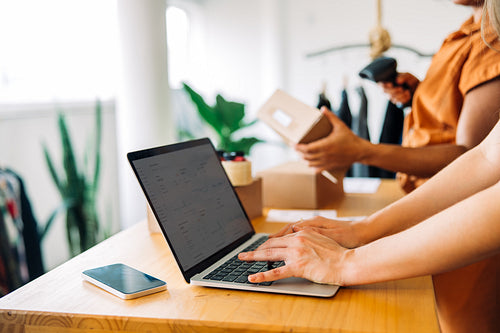 Online store worker using a laptop in a shop