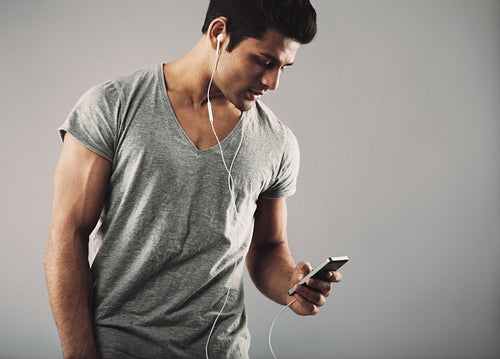 Young guy enjoying listening music on smartphone