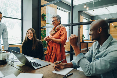 Diverse businesspeople smiling cheerfully during an office meeti