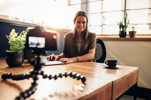 Young female vlogger recording content for her video blog.