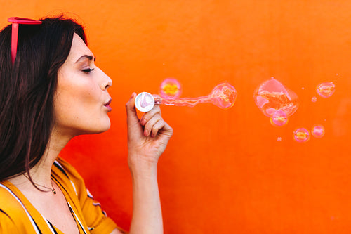 Beautiful woman blowing soap bubbles 