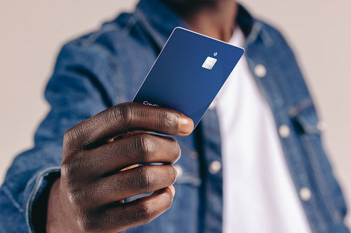 Modern banking at its finest: Male shopper makes an electronic payment using a credit card in a studio