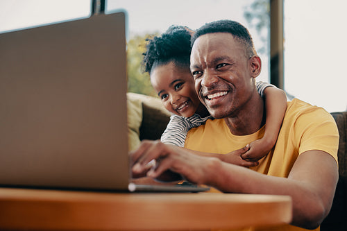 Father plays a kids movie for his daughter on a laptop