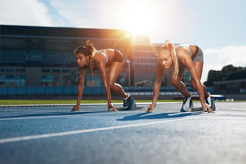 Determined female athletes ready to start a race