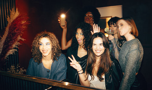 Group of friends having fun and posing together in a nightclub bathroom