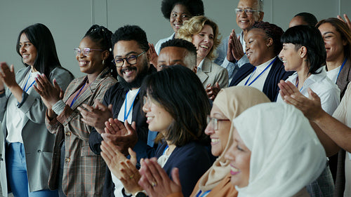 A diverse group of happy business professionals applauding at a successful conference event