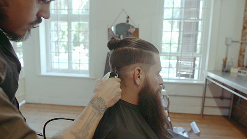 Hairstylist cutting hair of customer