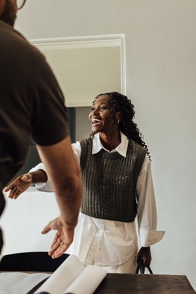 Young professional woman smiling and shaking hands in a modern office setting