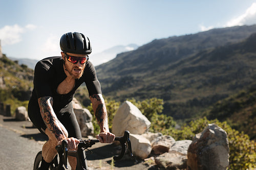 Sportsman cycling on hilly road