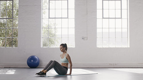 Woman doing lower abs workout at fitness studio