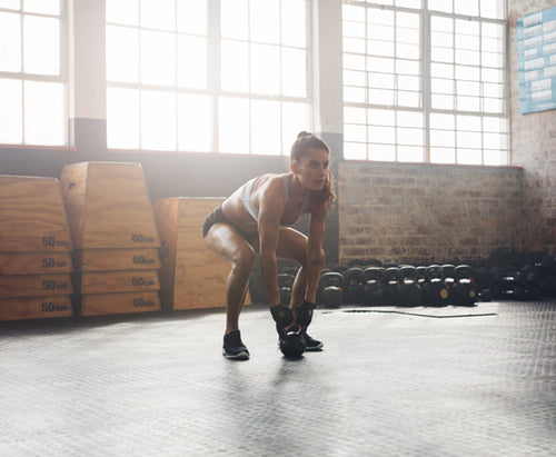 Muscular woman doing crossfit workout at gym