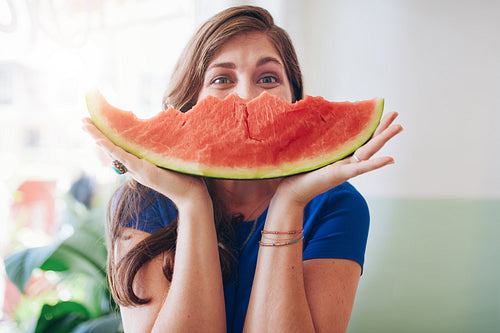 Young woman holding a slice of watermelon