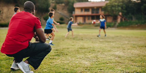 Coach having a practice session with kids in a school