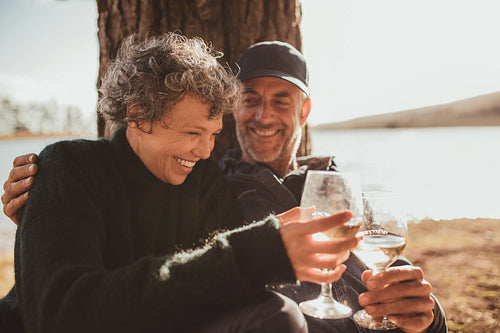 Relaxed mature couple having a glass of wine at campsite