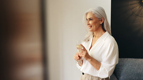 Mature woman enjoying a glass of wine as she celebrates her retirement