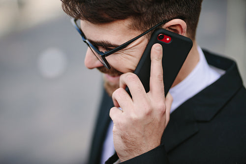 Smiling businessman talking on smartphone