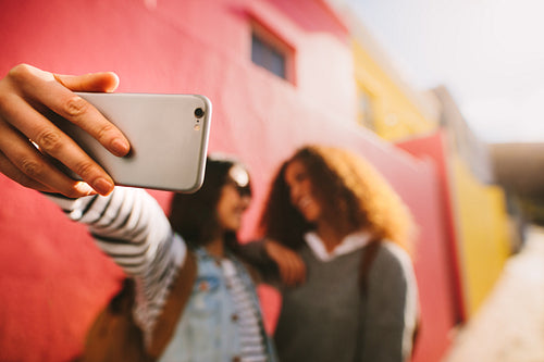 Woman taking selfie with female friend