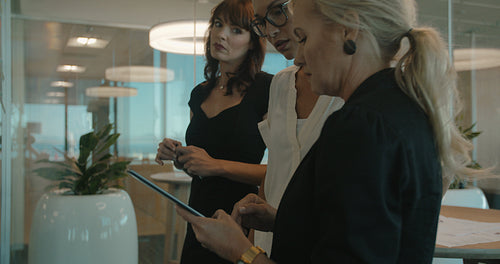 Business colleagues brainstorming together at a glass wall