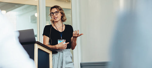 Woman speaking at business conference with presentation