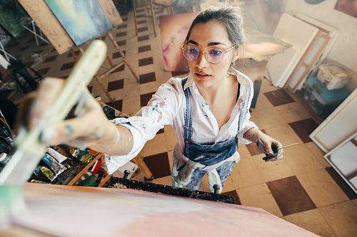 Artist painting while wearing tinted glasses