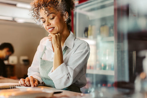 Happy business owner calculating her monthly expenses