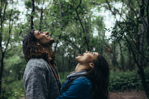 Couple enjoying the rain in forest