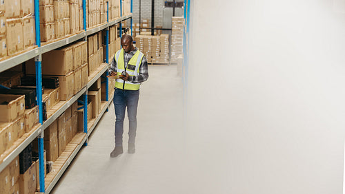 Warehouse manager taking inventory using a clipboard