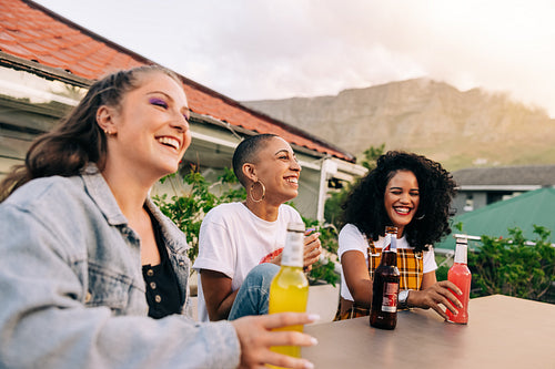 Female friends enjoying some cold drinks on a rooftop
