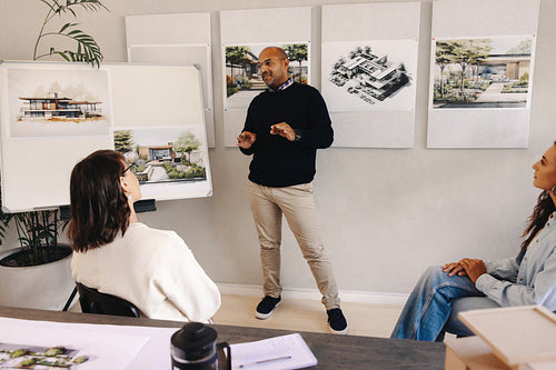 Male project manager briefing teammates during a planning session in an office