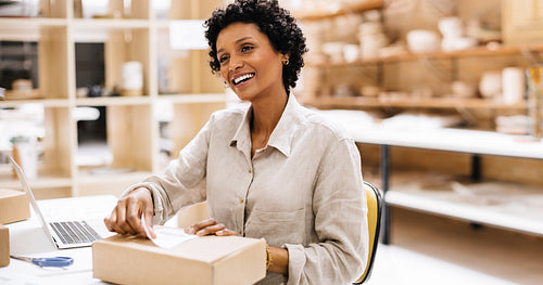 Happy online store owner preparing an order for shipping