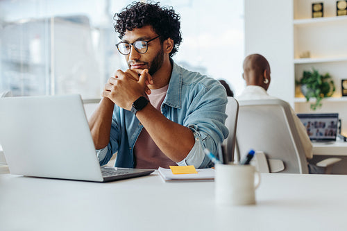 Happy entrepreneur working on laptop at modern office table