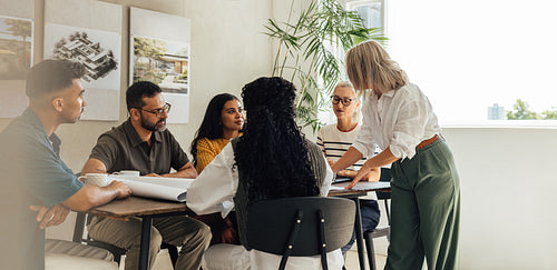 Team of diverse architects discussing a project in a modern office space