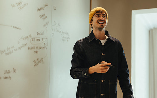 Casual meeting brings a man to the whiteboard for team presentation